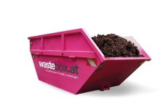Pinkfarbener wastebox.at Container mit Bio-Hochbeeterde – Lieferung hochwertiger, torffreier Pflanzenerde direkt nach Hause.
